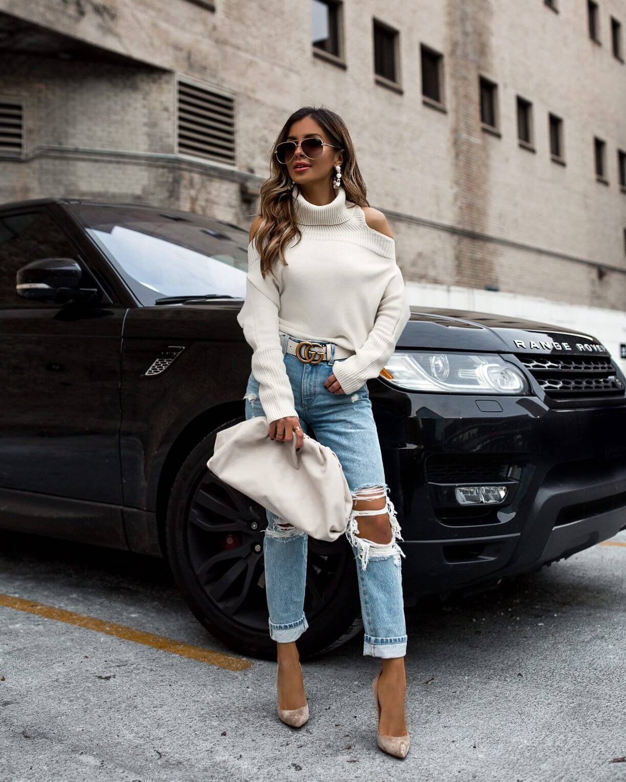 fashion blogger mia mia mine wearing a white off-the-shoulder sweater from revolve with a gucci belt and grlfrnd distressed denim