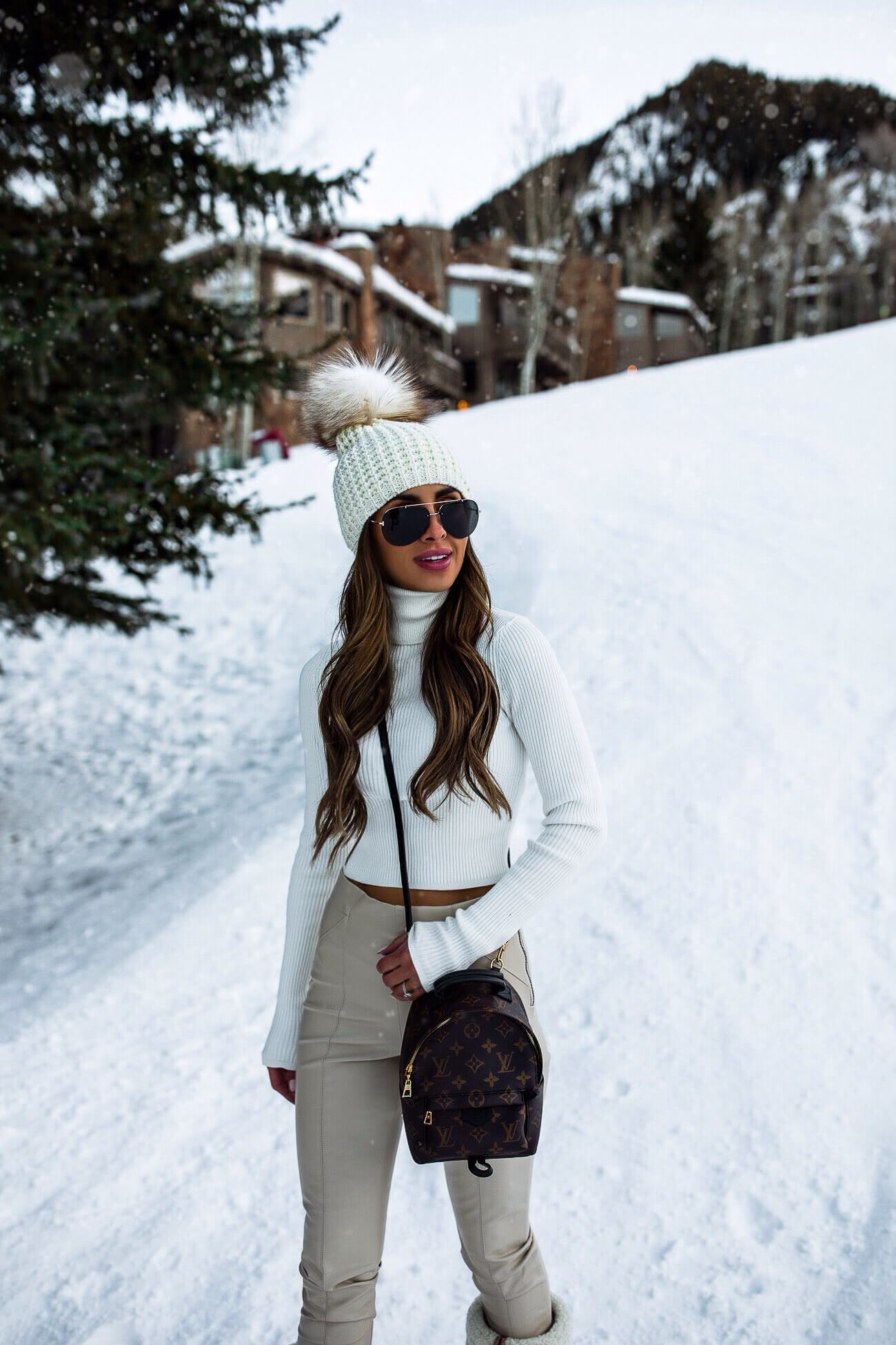 fashion blogger wearing a pom pom beanie and white winter outfit in Aspen Colorado