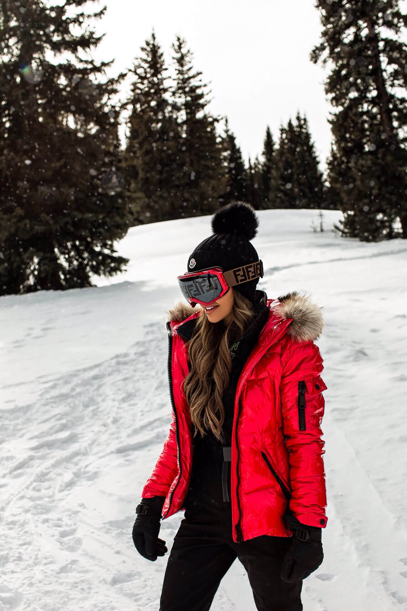 fashion blogger mia mia mine wearing a red puffer coat and fendi ski goggles