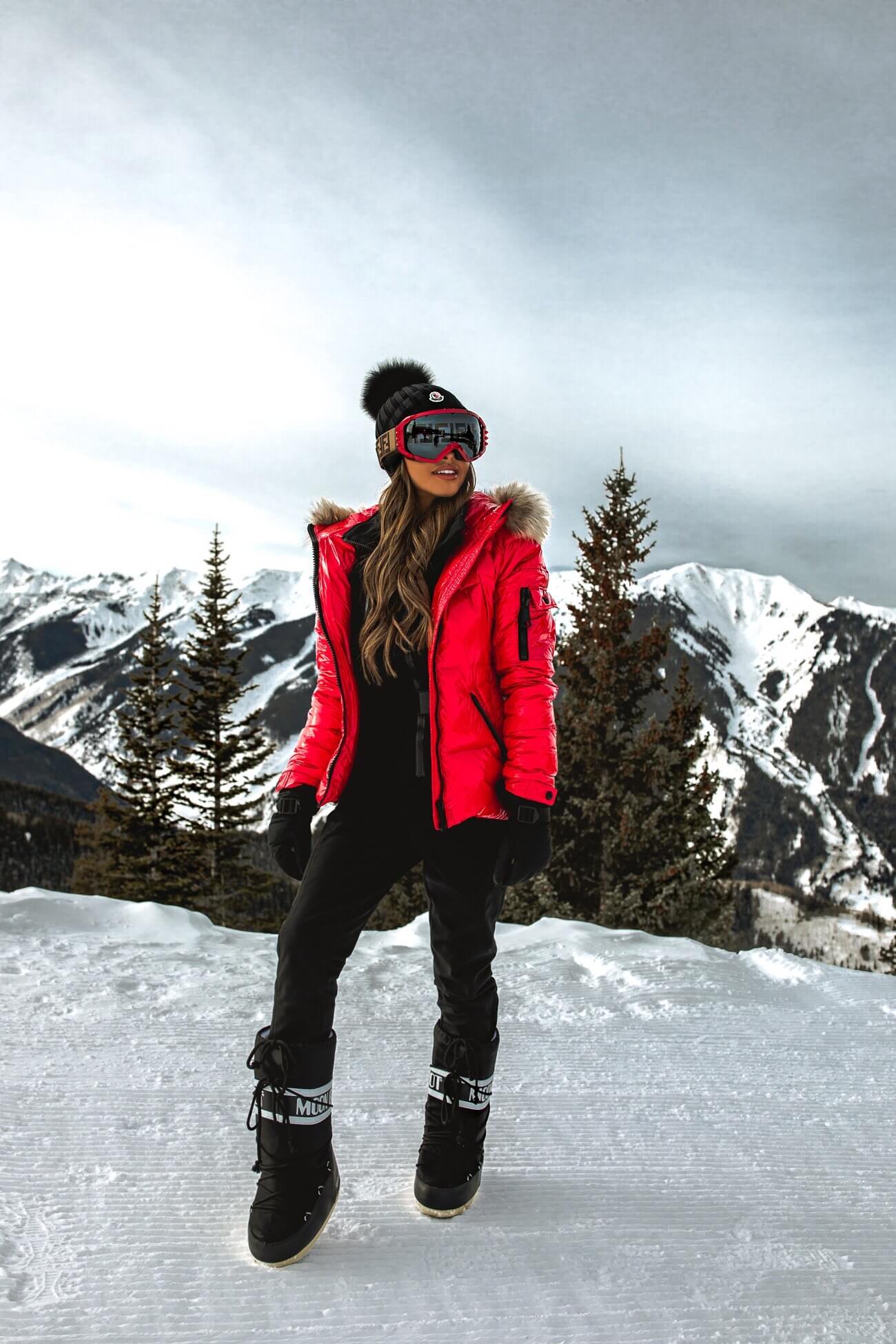 mia mia mine wearing a red puffer jacket and a topshop ski suit in aspen colorado