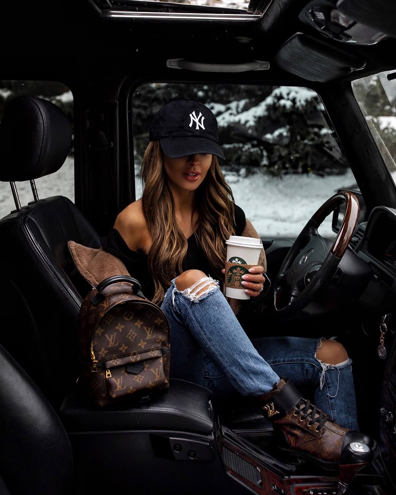 fashion blogger mia mia mine wearing combat boots and a louis vuitton mini backpack