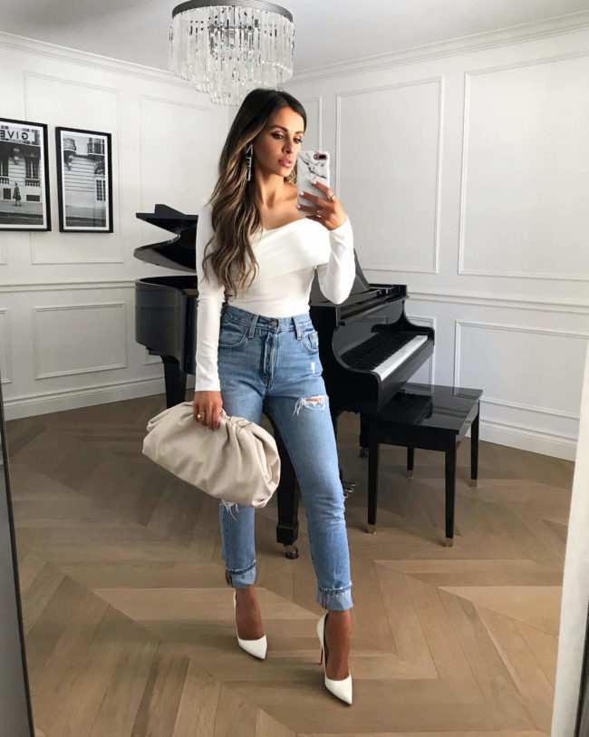fashion blogger mia mia mine wearing a white off shoulder top and a bottega veneta pouch in mist