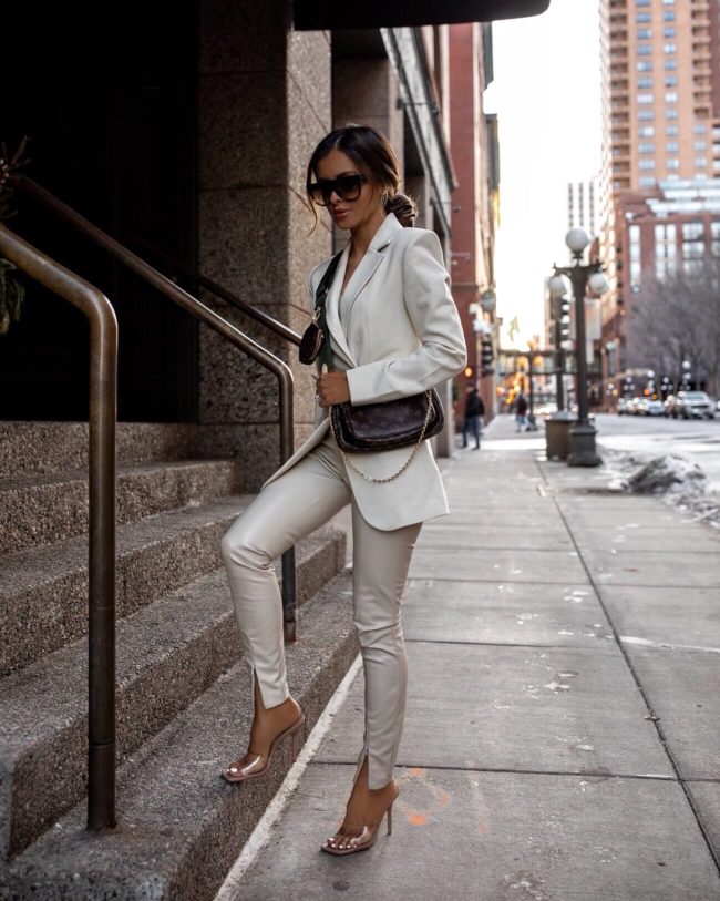 fashion blogger wearing a white blazer and faux leather pants from & other stories with the louis vuitton multi pochette accessoires