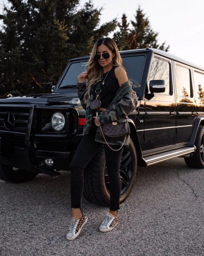 fashion blogger mia mia mine wearing a camo jacket and louis vuitton multi-pochette accessories