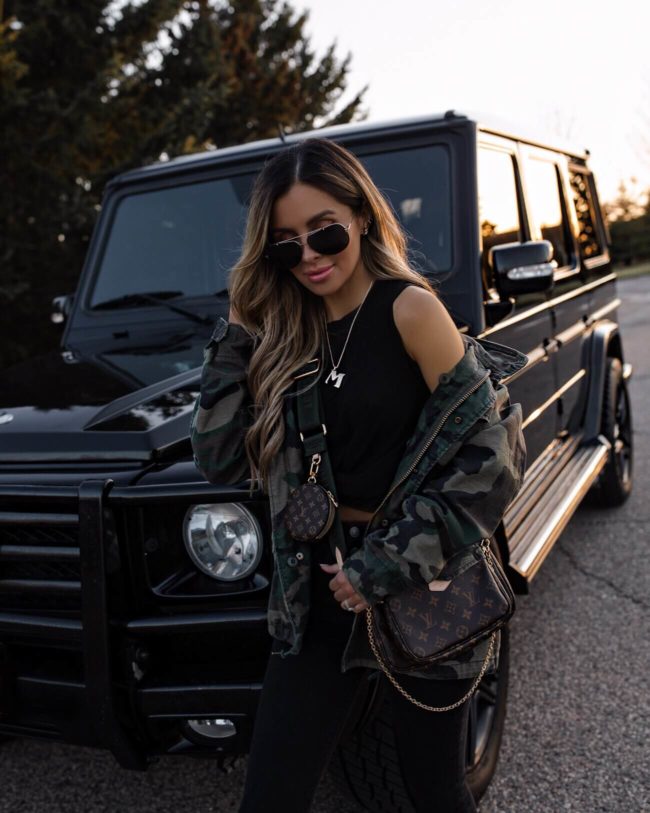 fashion blogger mia mia mine wearing a camo jacket and a baublebar necklace