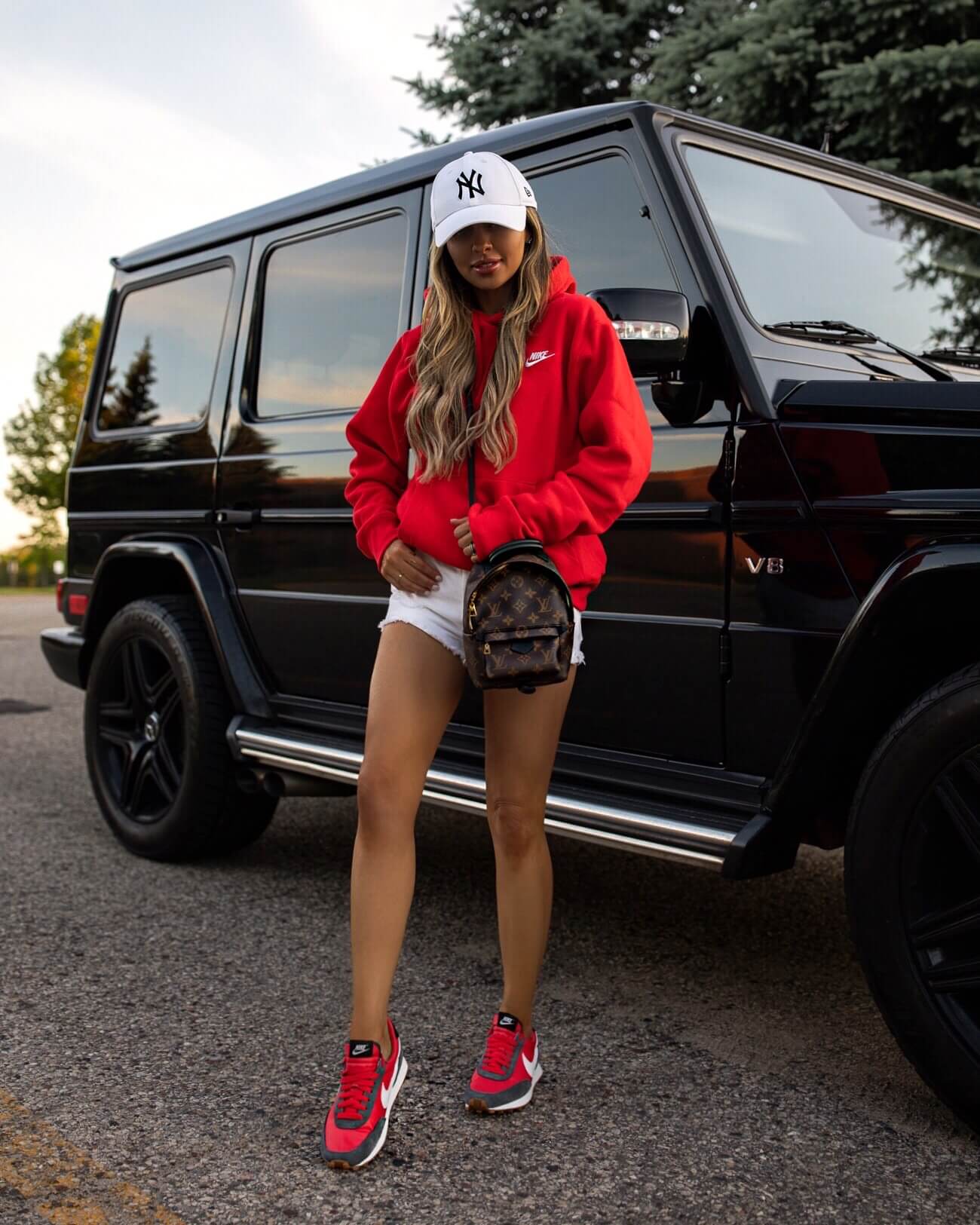 fashion blogger mia mia mine wearing a red sweatshirt and red nike sneakers