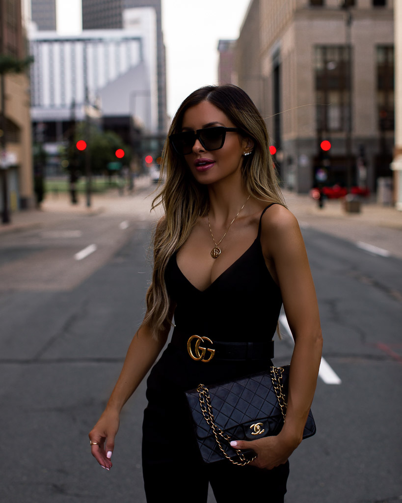 fashion blogger mia mia mine wearing a black jumpsuit and a gucci belt