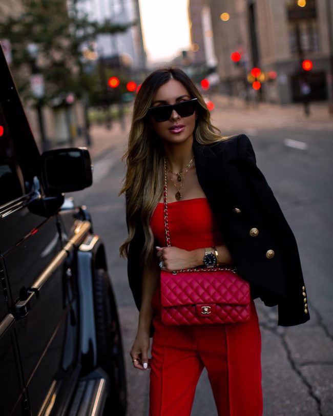 fashion blogger mia mia mine wearing a red jumpsuit and a balmain blazer