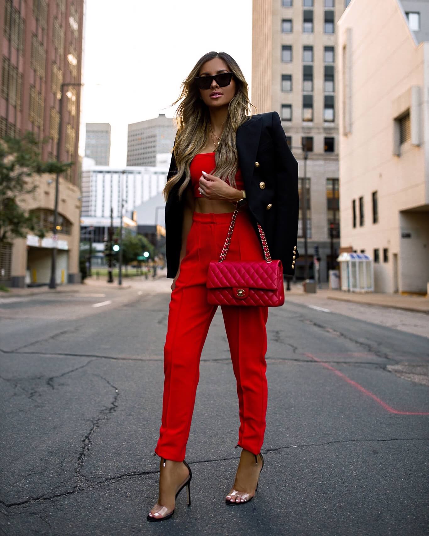 fashion blogger mia mia mine wearing a red matching set with a black balmain blazer and a red chanel bag