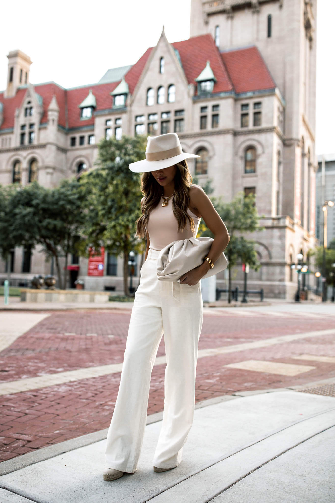 fashion blogger mia mia mine wearing white linen pants and a janessa leone hat for summer 2020