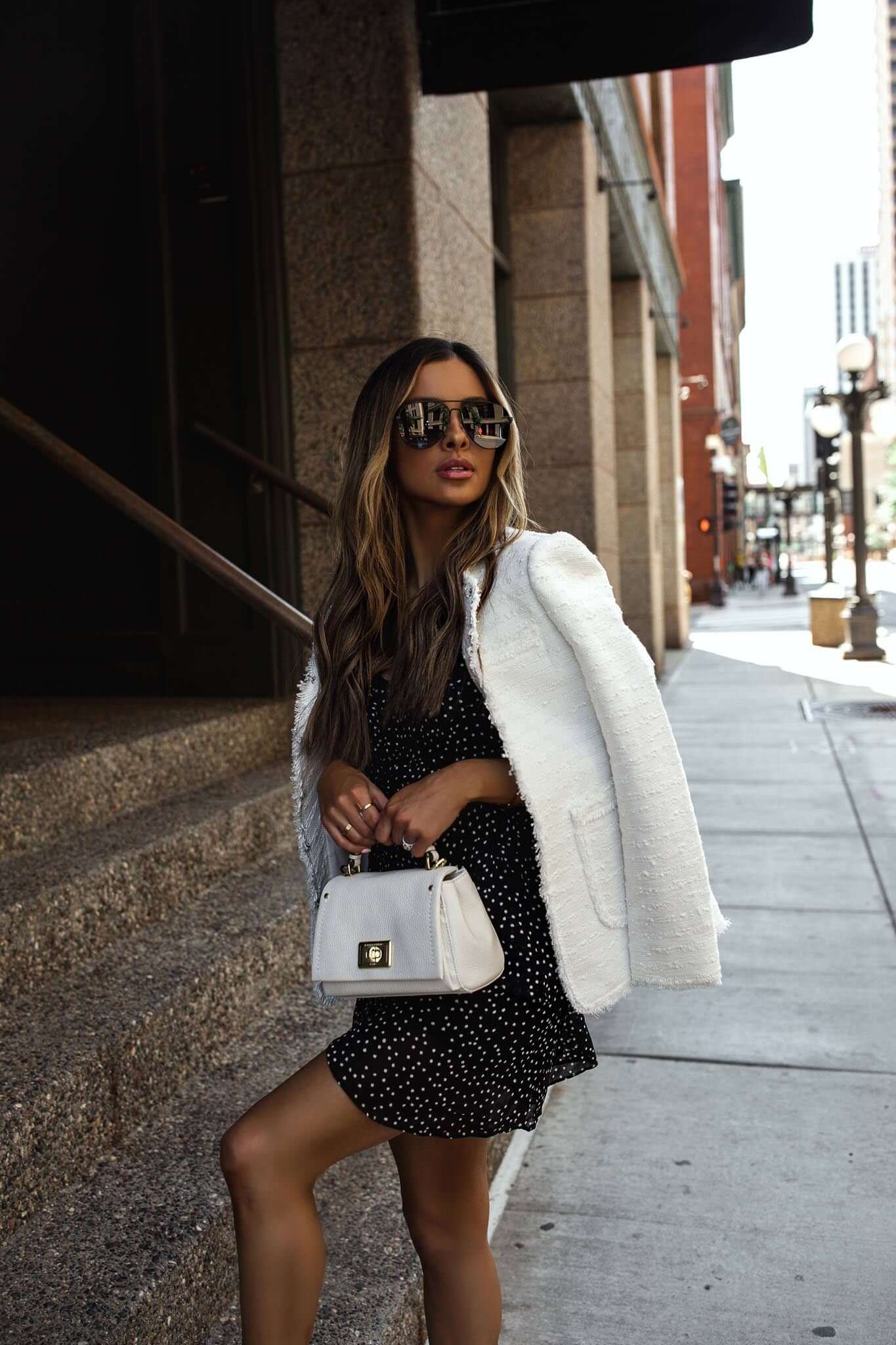 fashion blogger mia mia mine wearing a white blazer and white handbag