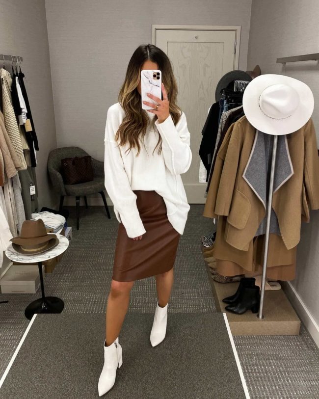 fashion blogger mia mia mine wearing a white sweater from the nordstrom anniversary sale with a faux leather skirt