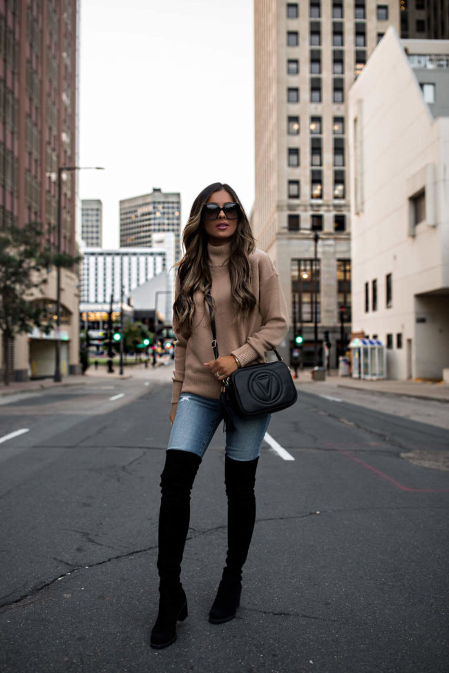 fashion blogger wearing a camel sweater denim and over-the-knee boots for fall