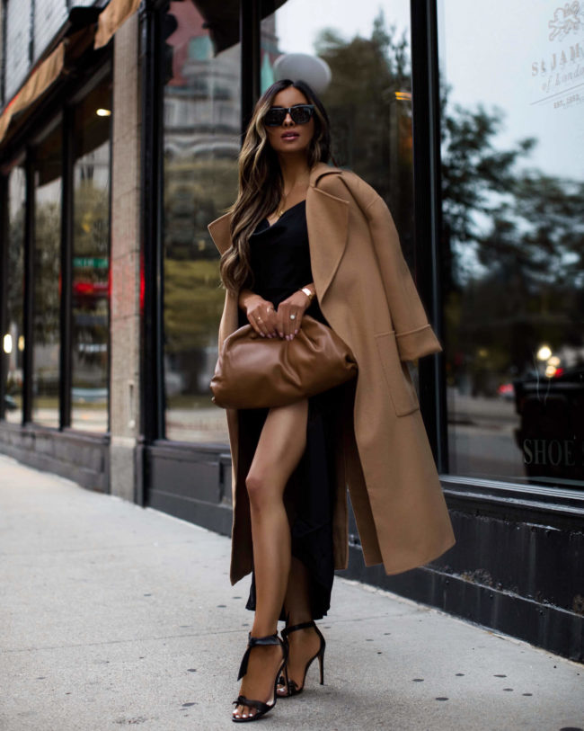 fashion blogger mia mia mine wearing an intermix camel coat with a slip dress