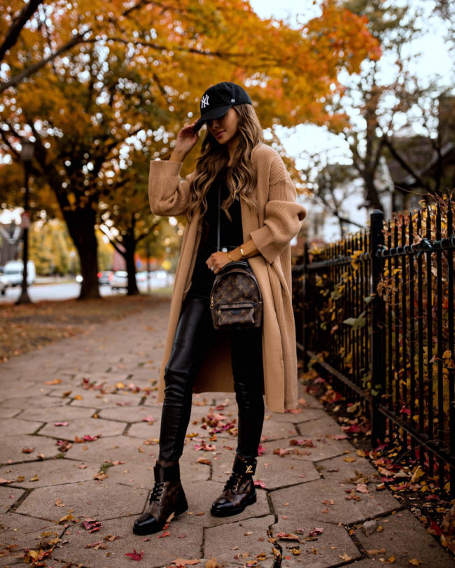fashion blogger mia mia mine wearing a camel coat and louis vuitton wonderland flat rangers
