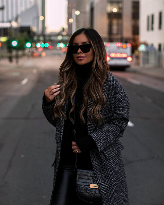 fashion blogger mia mia mine wearing a plaid coat and black turtleneck sweater from walmart
