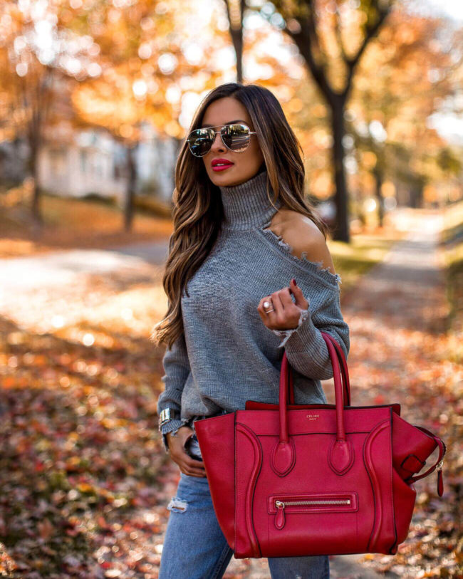 fashion blogger mia mia mine wearing a gray chunky turtleneck sweater from revolve and a red celine bag