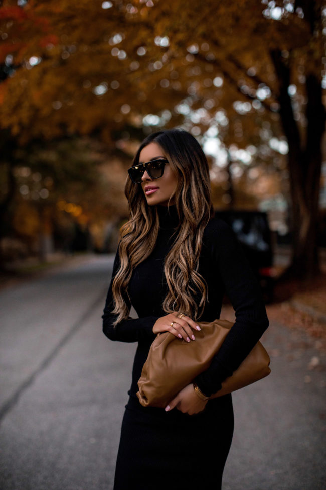 fashion blogger mia mia mine wearing a black sweater dress and a bottega veneta bag for fall
