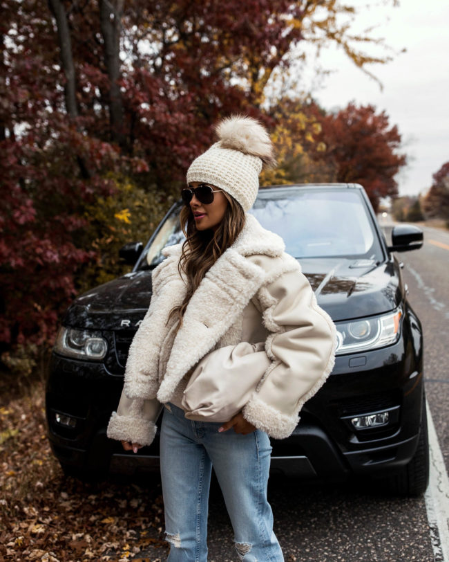 fashion blogger wearing a shearling coat and mother denim from intermix