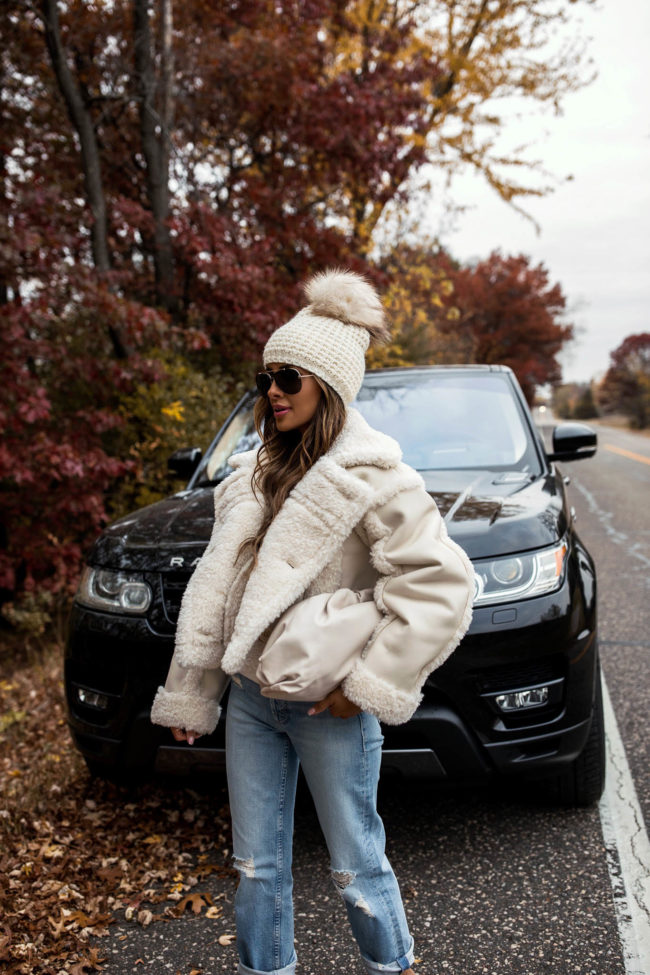 fashion blogger wearing a shearling coat and mother denim from intermix