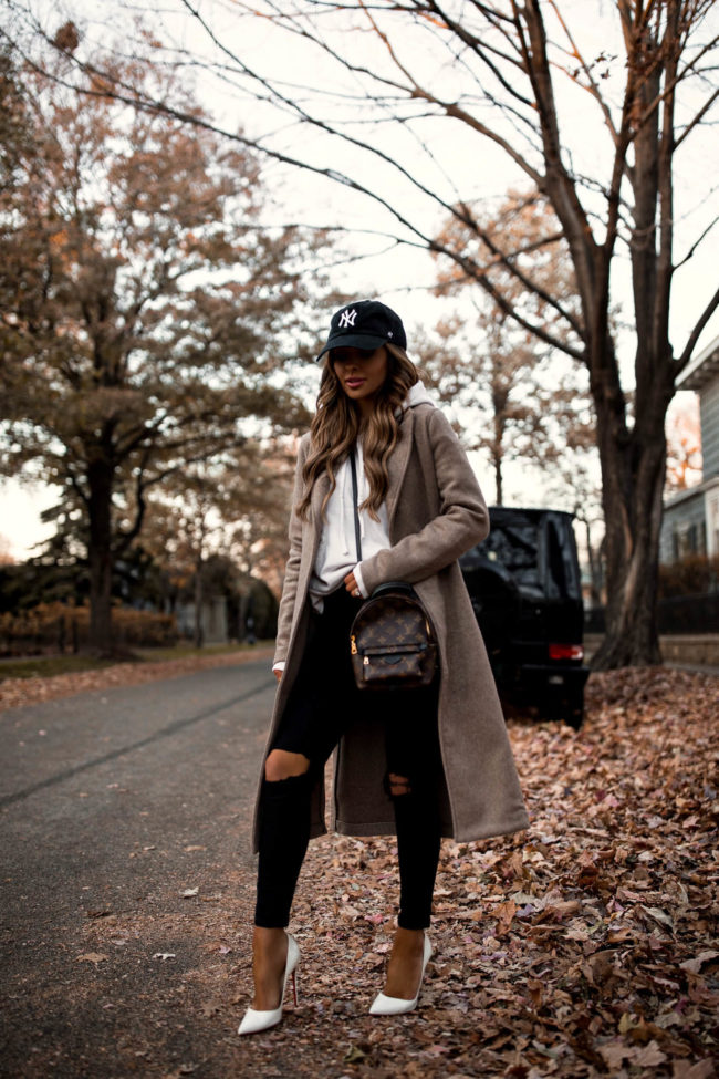 fashion blogger mia mia mine wearing a wool coat from abercrombie with a NY Yankees cap