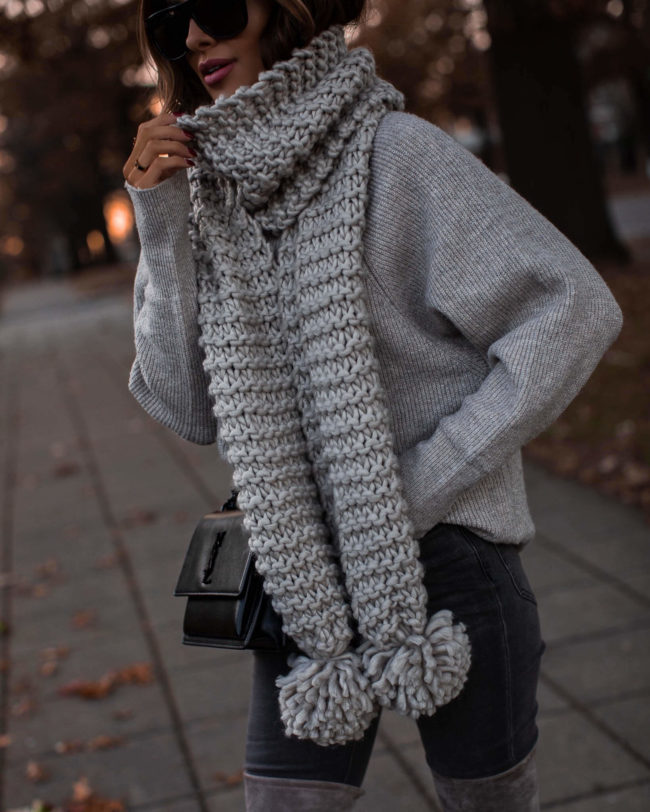 fashion blogger wearing a chunky knit pom pom scarf from express