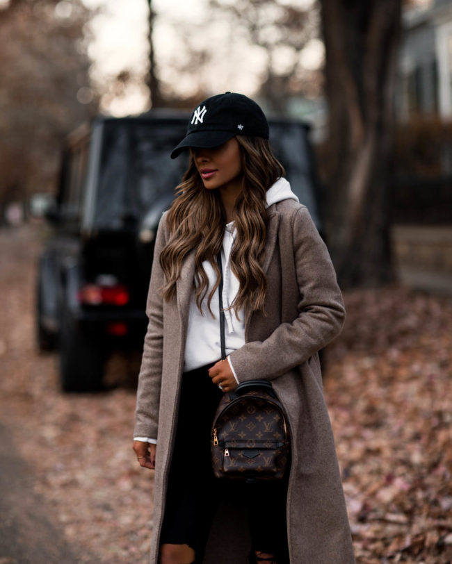 fashion blogger wearing a baseball cap and sweatshirt outfit