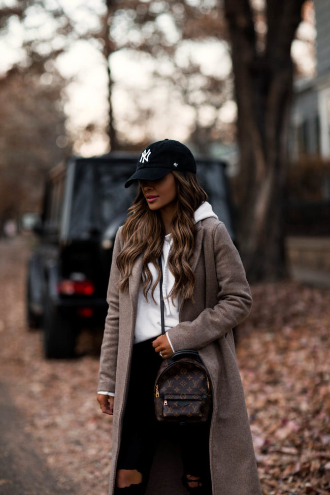 fashion blogger wearing a baseball cap and sweatshirt outfit