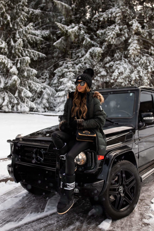 fashion blogger mia mia mine wearing a green winter coat and moon boots for winter