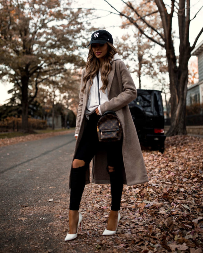 fashion blogger mia mia mine wearing a wool coat from abercrombie with a NY Yankees cap
