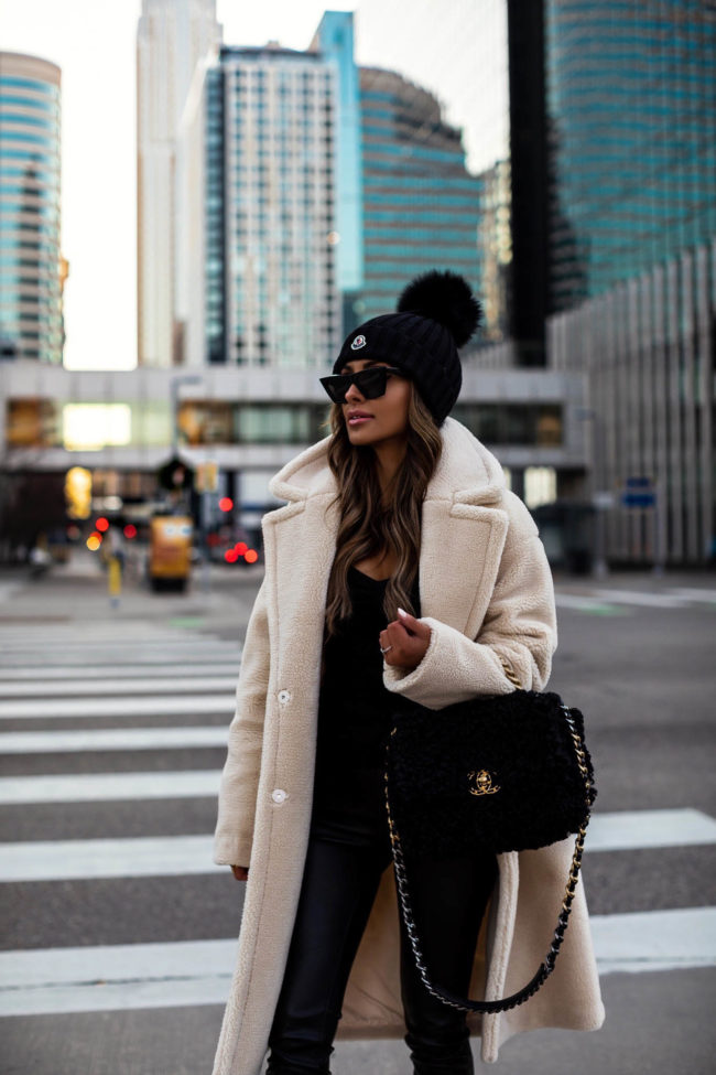 fashion blogger mia mia mine wearing a faux shearling jacket from express with a chanel 19 bag