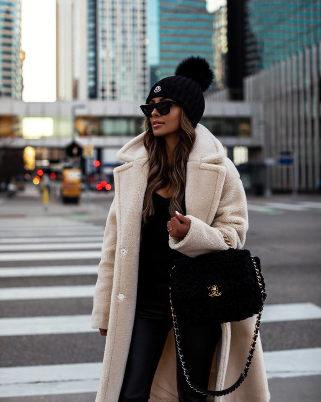 fashion blogger mia mia mine wearing a faux shearling jacket from express with a chanel 19 bag