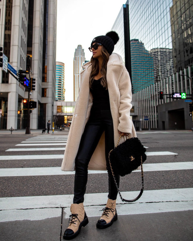 fashion blogger mia mia mine wearing a faux shearling jacket from express with chanel combat boots and chanel 19 bag
