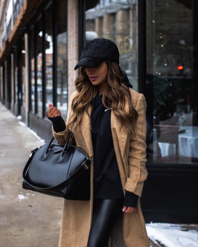 fashion blogger wearing a nike sweatshirt and a faux fur baseball hat from nordstrom