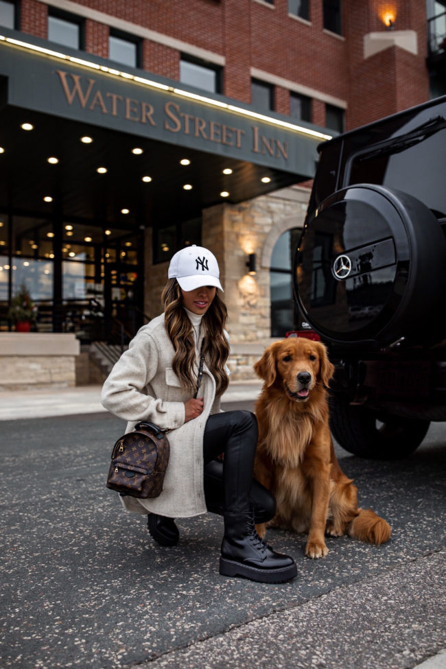 fashion blogger mia mia mine wearing a casual winter outfit with her golden retriever