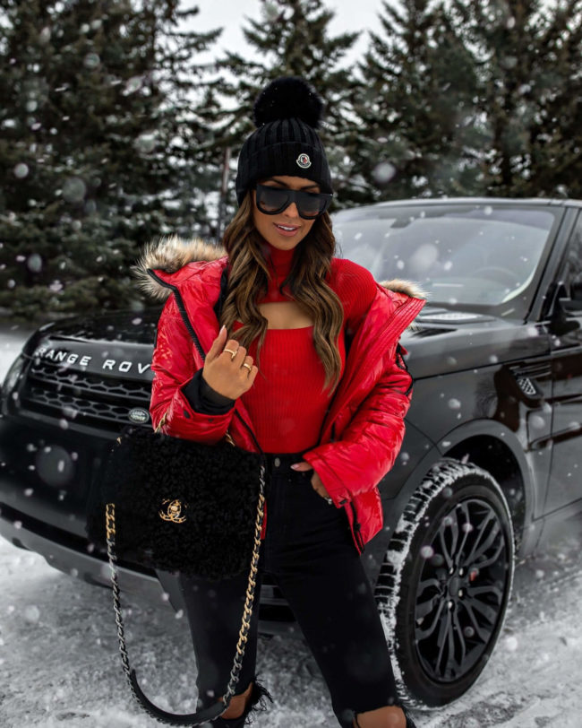 fashion blogger mia mia mine wearing a red sweater from revolve and a moncler beanie