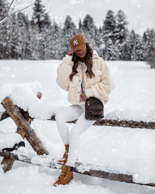 fashion blogger mia mia mine wearing an all white outfit with a shearling jacket from free people in jackson hole
