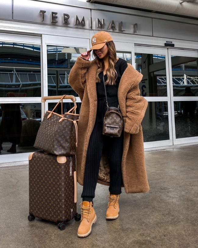 fashion blogger mia mia mine wearing a max mara teddy bear coat and ribbed jumpsuit while traveling