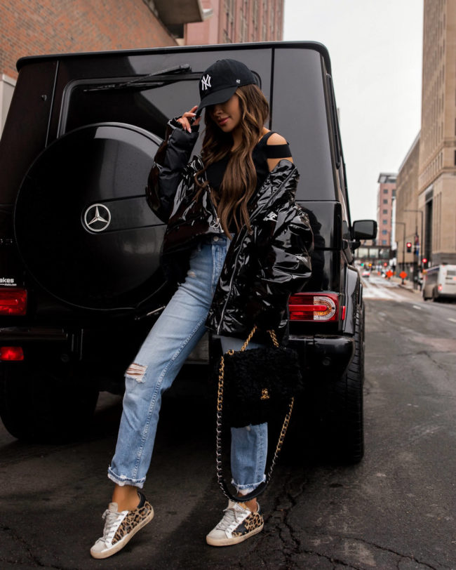 fashion blogger wearing a nike puffer jacket and mother mom jeans from revolve