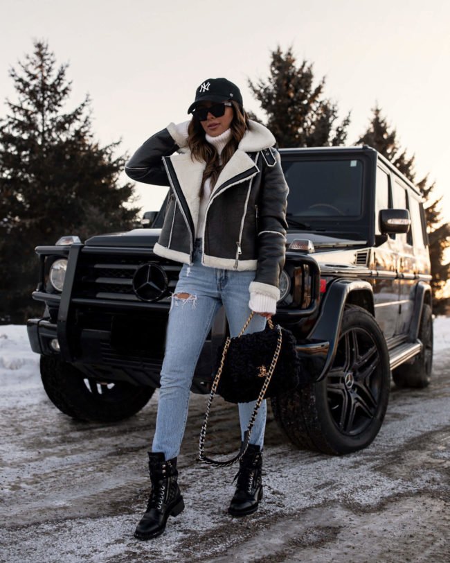 fashion blogger mia mia mine wearing a shearling jacket from revolve with chanel combat boots