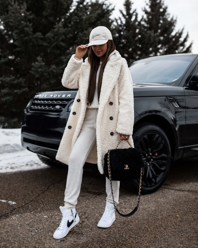 fashion blogger mia mia mine wearing a white teddy bear coat and nike high top blazer sneakers for winter