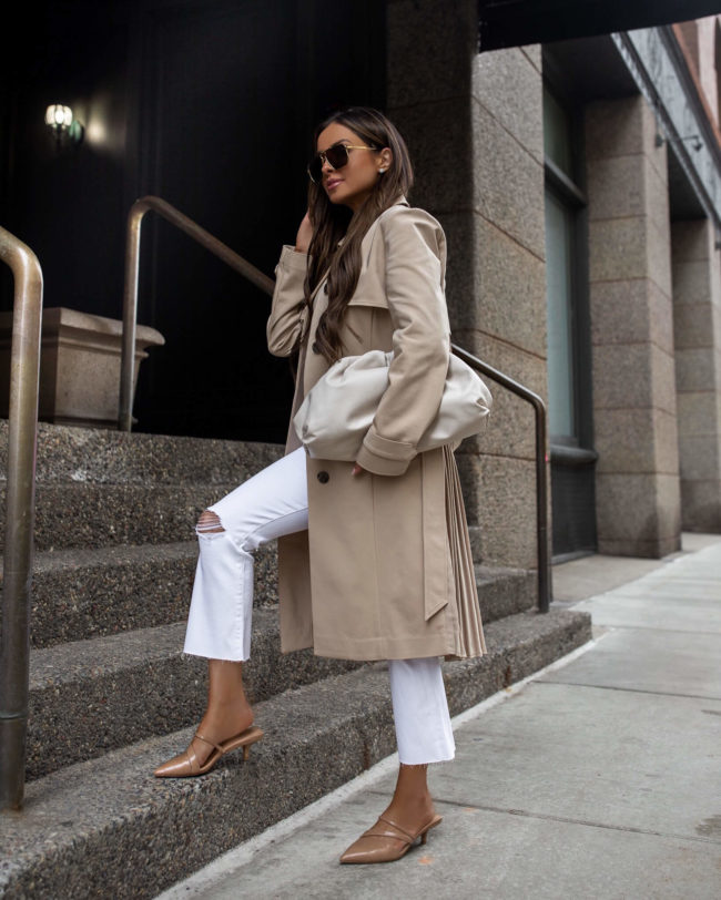 fashion blogger mia mia mine wearing a trench coat and white denim from express