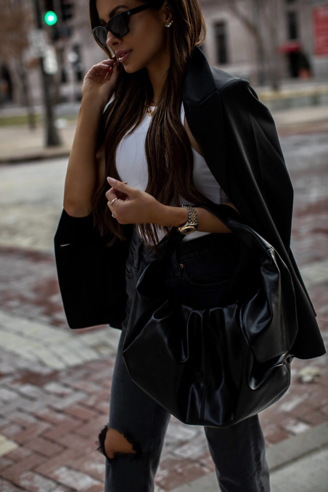fashion blogger carrying a black bag from express