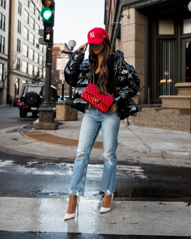 fashion blogger mia mia mine wearing a red ny yankees cap and red chanel bag