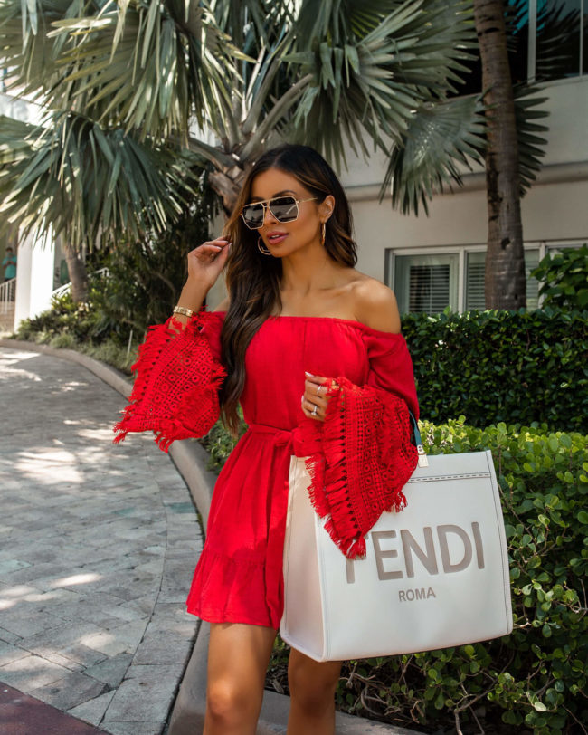 fashion blogger wearing a red dress and white fendi sunshine tote in miami