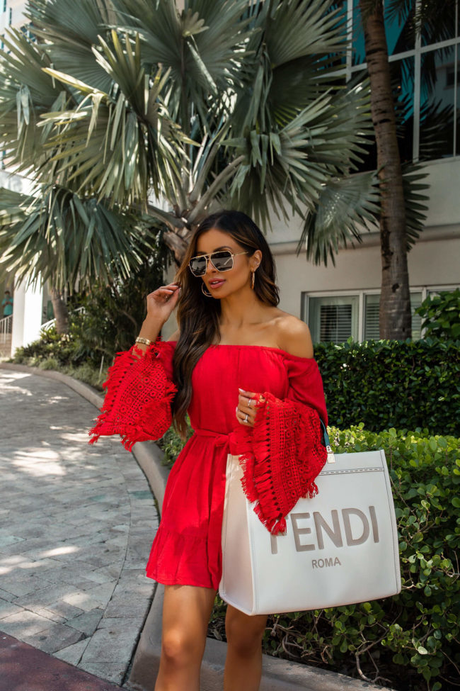 fashion blogger wearing a red dress and white fendi sunshine tote in miami