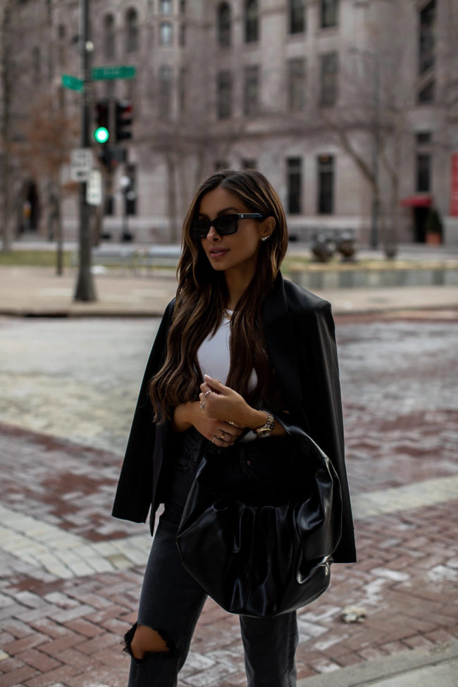 fashion blogger mia mia mine wearing a black shoulder bag from express and a black blazer