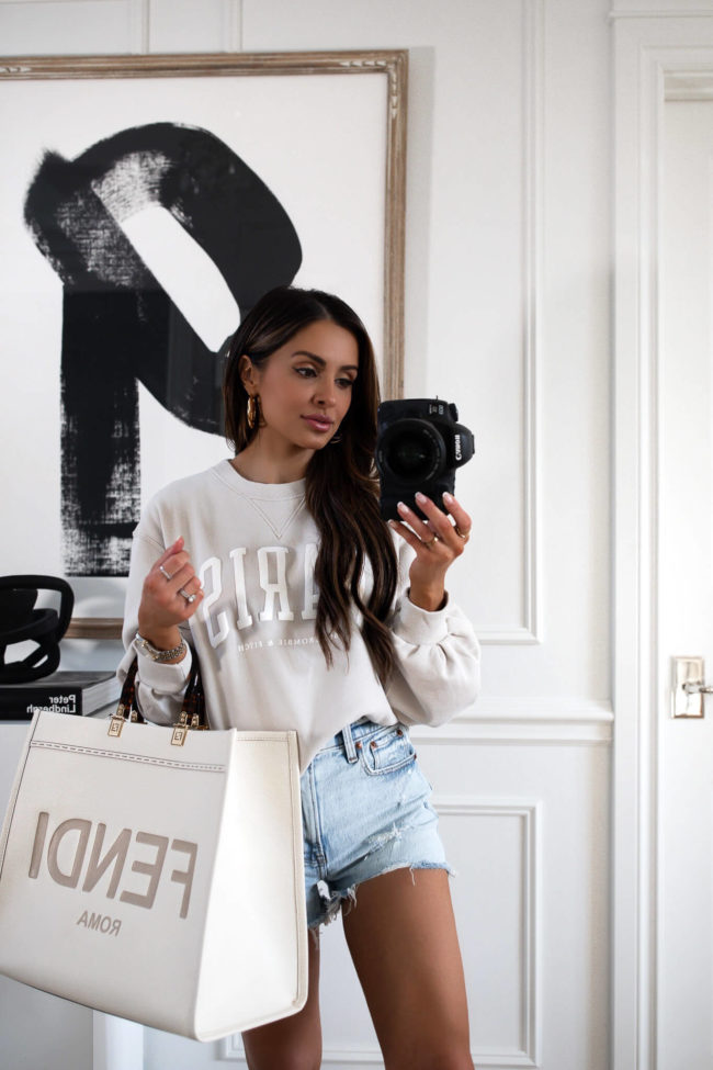 fashion blogger mia mia mine wearing a paris sweatshirt and fendi sunshine bag