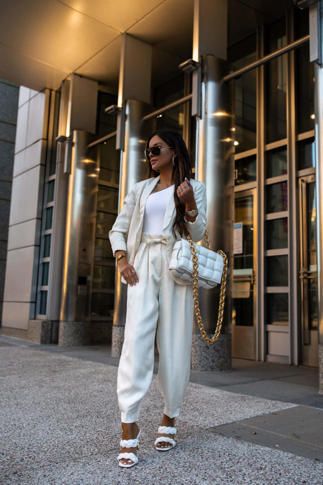 fashion blogger mia mia mine wearing a white linen suit and bottega veneta bag