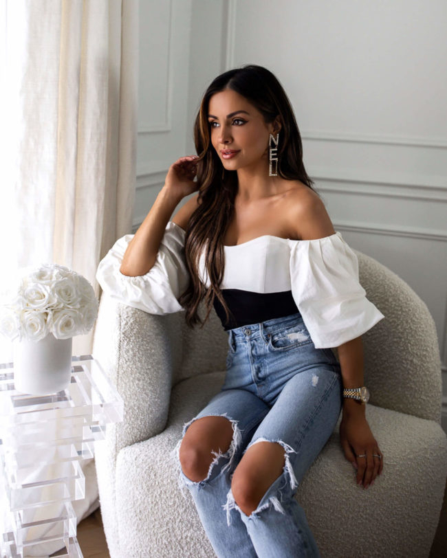 fashion blogger mia mia mine wearing a white off-the-shoulder bodysuit from nordstrom with chanel earrings